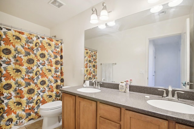 bathroom featuring double vanity, visible vents, toilet, and a sink