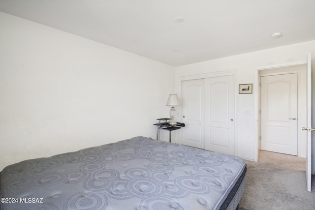 unfurnished bedroom featuring a closet and light colored carpet