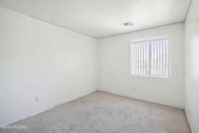 spare room featuring light carpet and visible vents