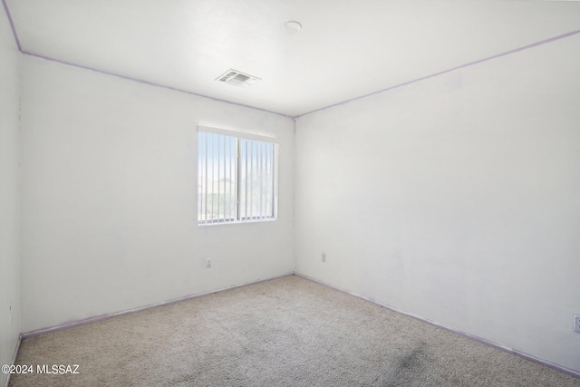 spare room featuring carpet flooring and visible vents