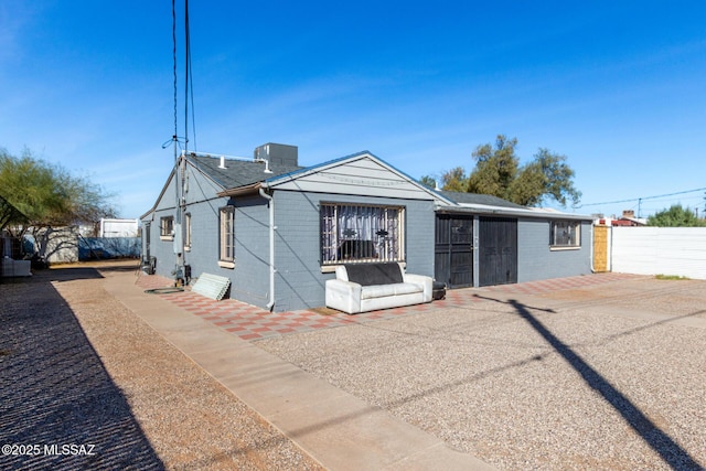 view of front of house with brick siding and fence