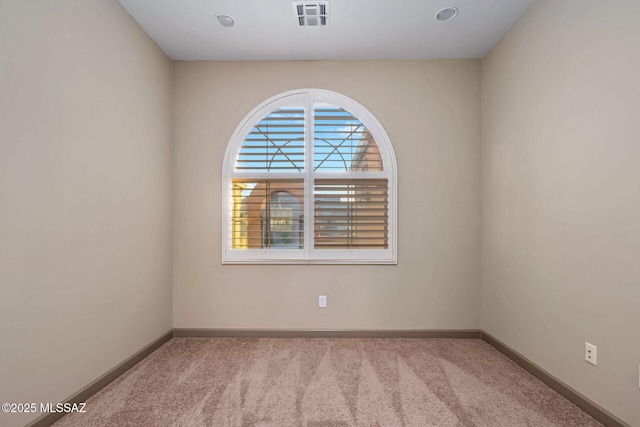 unfurnished room with visible vents, baseboards, and carpet floors