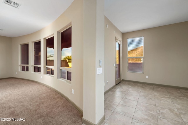 unfurnished room with light tile patterned floors, baseboards, and visible vents