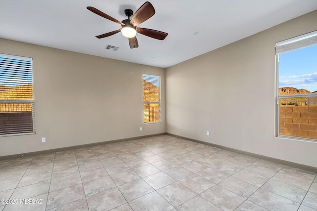 unfurnished room featuring light tile patterned floors, visible vents, baseboards, and ceiling fan