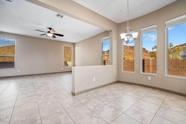 empty room with light tile patterned floors, visible vents, and baseboards