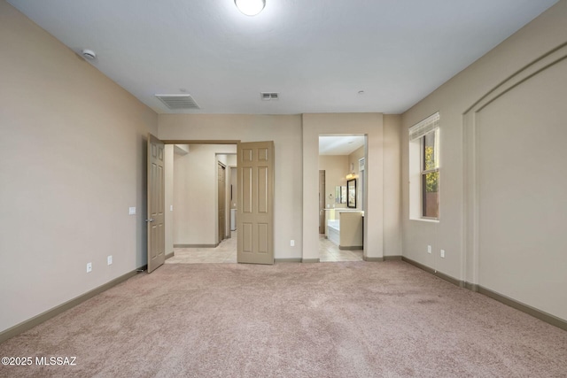 unfurnished bedroom featuring visible vents, light carpet, and baseboards