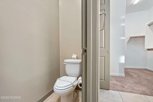 bathroom featuring tile patterned flooring, toilet, and baseboards