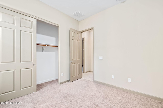 unfurnished bedroom featuring carpet, visible vents, a closet, and baseboards