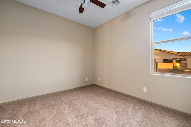 empty room featuring visible vents, ceiling fan, baseboards, and carpet