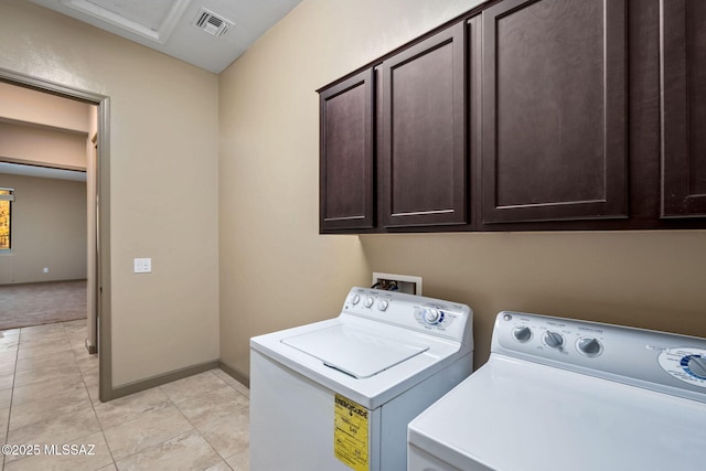 washroom with visible vents, washing machine and dryer, cabinet space, light tile patterned floors, and baseboards