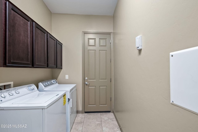 clothes washing area featuring light tile patterned floors, baseboards, cabinet space, and independent washer and dryer