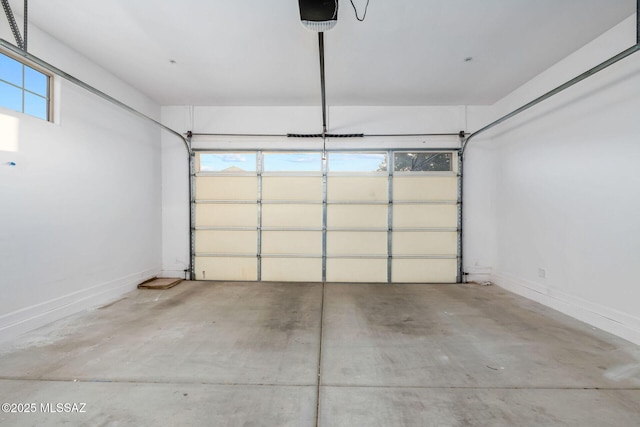 parking garage featuring a garage door opener and baseboards