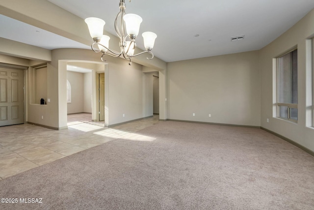 empty room with visible vents, baseboards, light carpet, light tile patterned floors, and an inviting chandelier