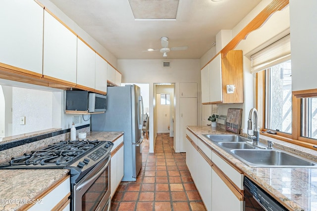 kitchen featuring visible vents, a sink, white cabinetry, stainless steel appliances, and light countertops