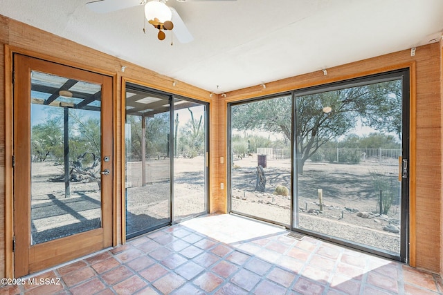 unfurnished sunroom featuring ceiling fan