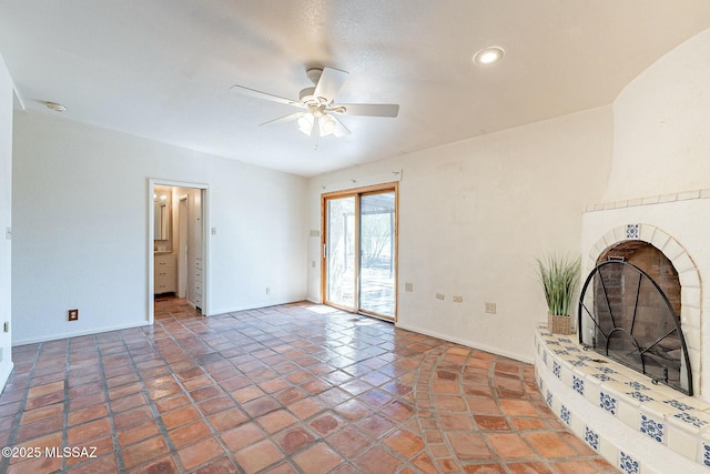 unfurnished living room with tile patterned floors, a ceiling fan, recessed lighting, a fireplace, and baseboards