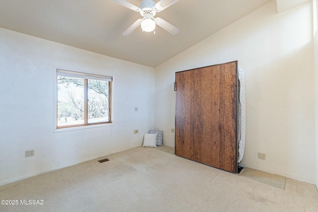 unfurnished bedroom with visible vents, carpet floors, a ceiling fan, and vaulted ceiling