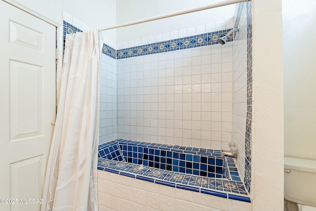 bathroom featuring toilet and tiled shower