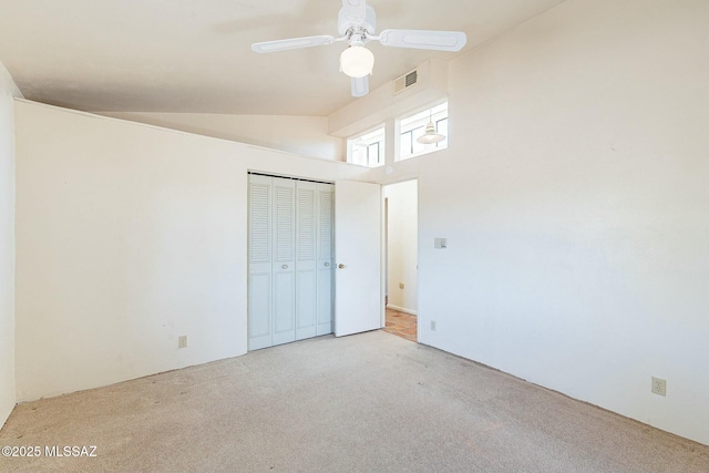 unfurnished bedroom with visible vents, ceiling fan, carpet, vaulted ceiling, and a closet