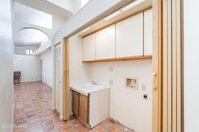 laundry area featuring hookup for a washing machine, arched walkways, cabinet space, electric dryer hookup, and a sink