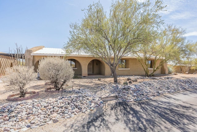 view of front of property with fence and stucco siding