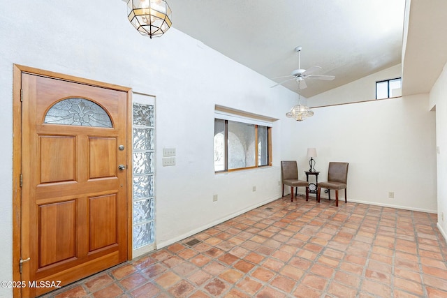 foyer with visible vents, baseboards, high vaulted ceiling, and ceiling fan with notable chandelier