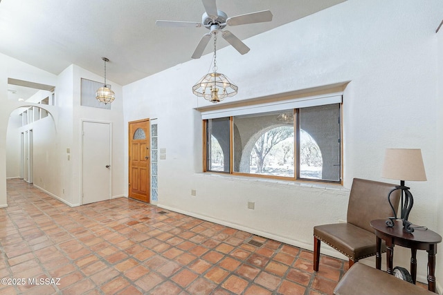 foyer featuring baseboards, visible vents, arched walkways, and ceiling fan