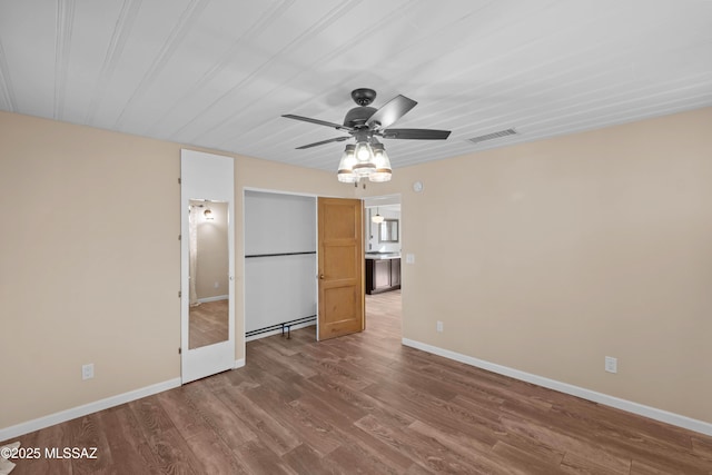 235 N Tucson Blvd, Tucson, AZ 85716 - unfurnished bedroom featuring wood finished floors, ceiling fan, baseboards, and visible vents