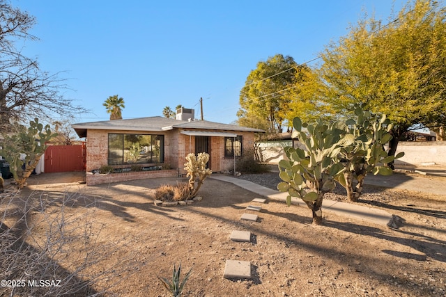 235 N Tucson Blvd, Tucson, AZ 85716 - view of front facade with brick siding, fence, and a chimney