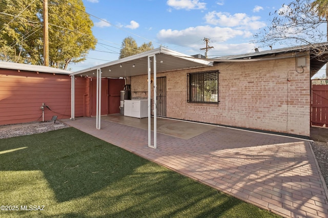 235 N Tucson Blvd, Tucson, AZ 85716 - rear view of house featuring a yard, a patio area, washing machine and clothes dryer, fence, and brick siding
