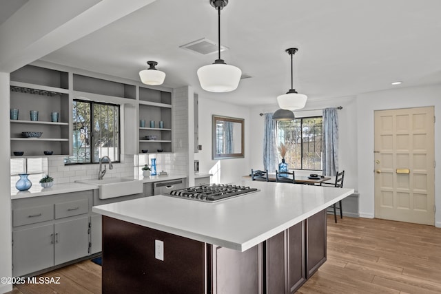 235 N Tucson Blvd, Tucson, AZ 85716 - kitchen featuring a sink, open shelves, stainless steel gas stovetop, and light wood finished floors