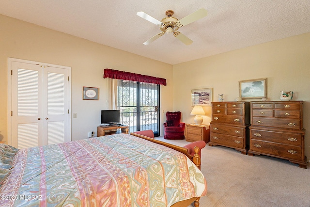 carpeted bedroom with a textured ceiling and a ceiling fan