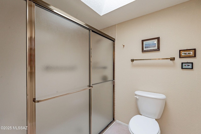 bathroom featuring a skylight, an enclosed shower, and toilet