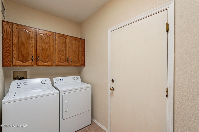 laundry room featuring light tile patterned floors, washer and clothes dryer, and cabinet space