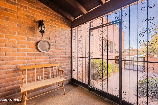 bathroom with lofted ceiling and brick wall