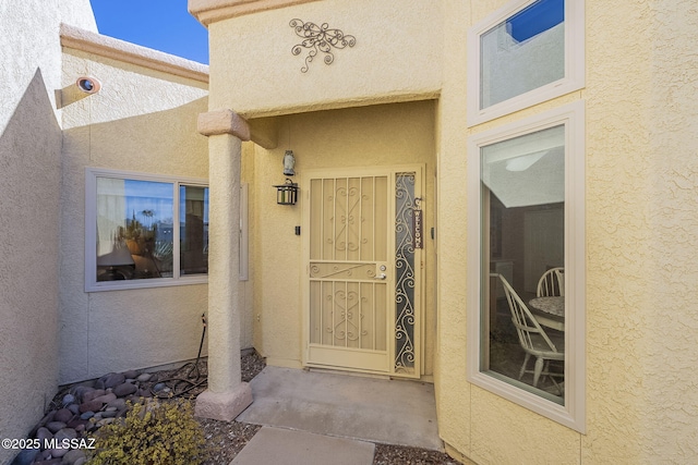 entrance to property featuring stucco siding