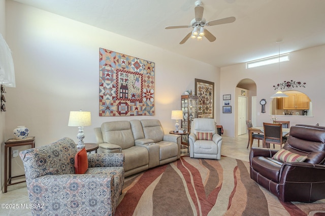 living area featuring arched walkways and a ceiling fan