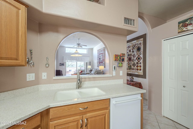 kitchen with light tile patterned floors, visible vents, arched walkways, white dishwasher, and a sink