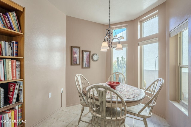 dining area featuring a chandelier, light tile patterned flooring, and baseboards