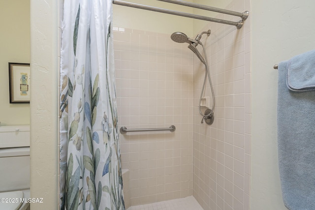 bathroom with a shower stall and toilet