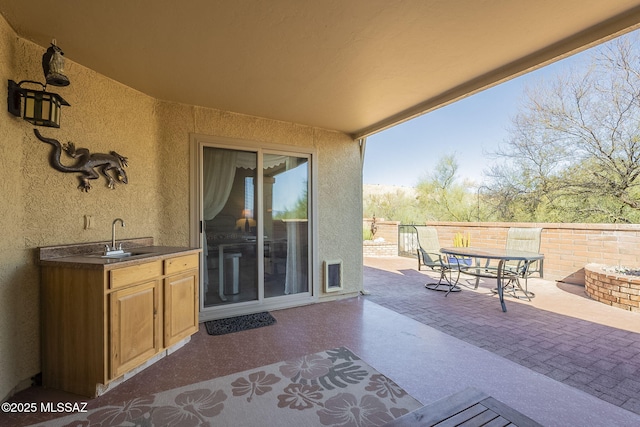 view of patio / terrace with a sink, visible vents, fence, exterior kitchen, and outdoor dining space