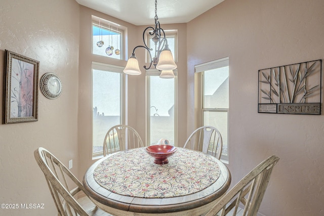 dining room with an inviting chandelier and a textured wall