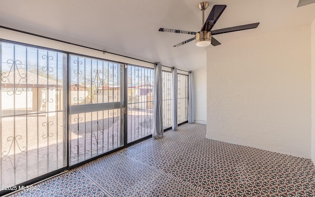 unfurnished sunroom with plenty of natural light, visible vents, and ceiling fan