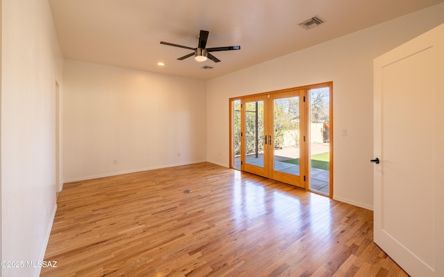 unfurnished room with ceiling fan, light wood-style flooring, visible vents, baseboards, and french doors