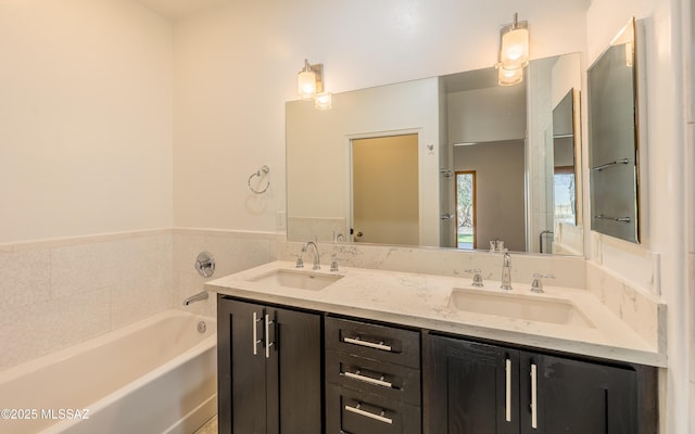 bathroom featuring double vanity, a sink, and a bath