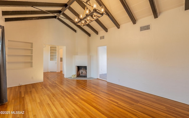 unfurnished living room featuring a fireplace with flush hearth, visible vents, high vaulted ceiling, and light wood-style flooring