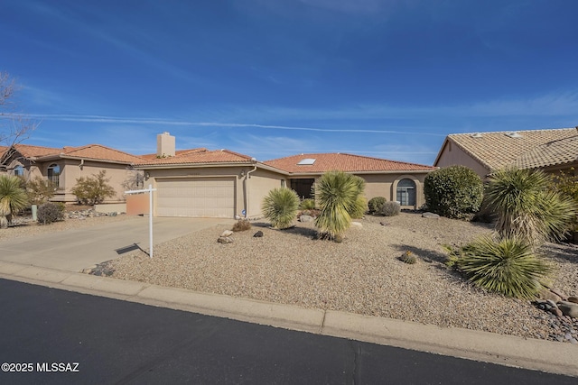 mediterranean / spanish-style house featuring a garage, concrete driveway, a chimney, a tiled roof, and stucco siding