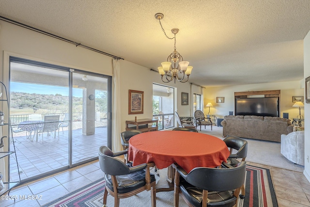 dining space featuring a textured ceiling, light tile patterned floors, and a notable chandelier