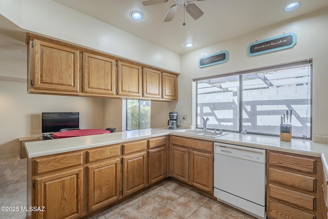 kitchen featuring a sink, a peninsula, light countertops, and dishwasher