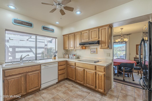 kitchen featuring under cabinet range hood, light countertops, black appliances, a sink, and ceiling fan with notable chandelier